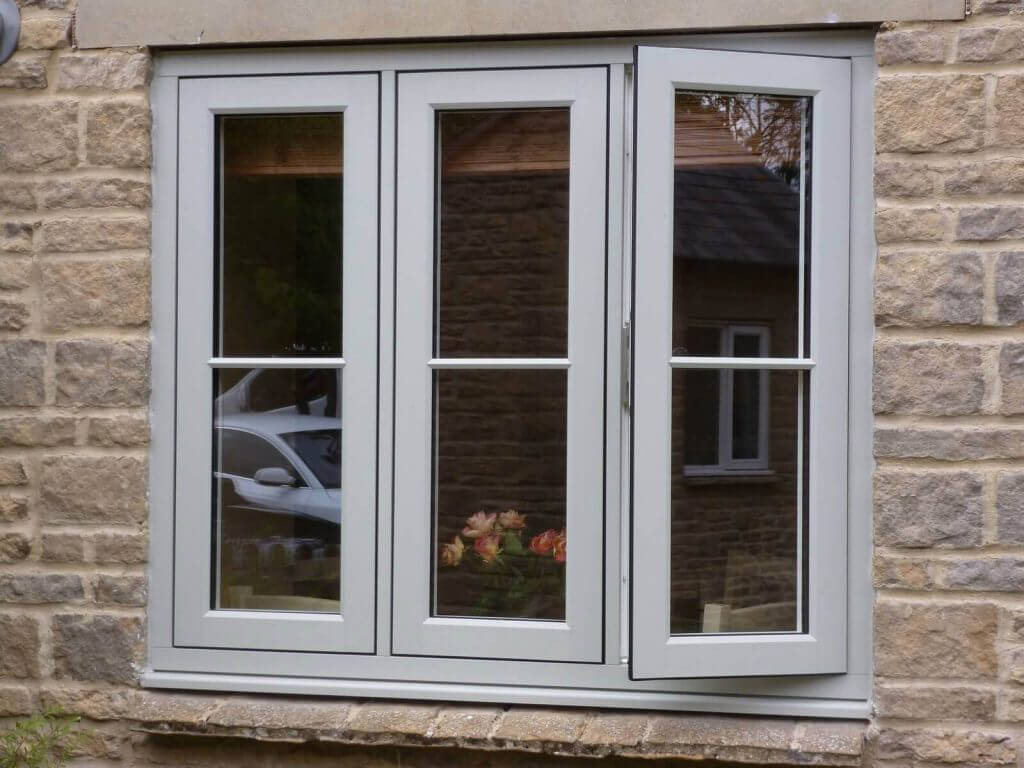 White-framed replacement windows in pale face brick house